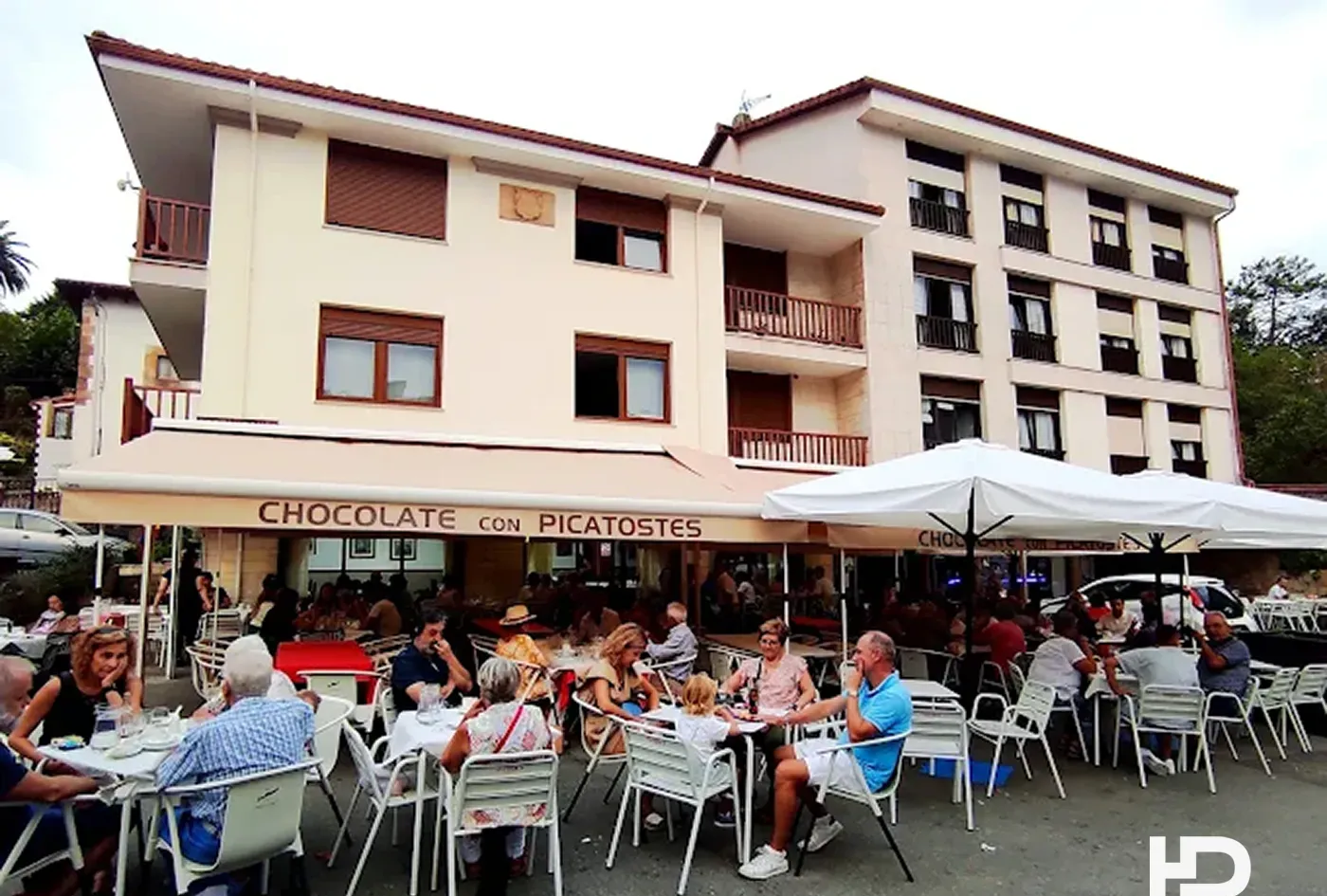 Terraza llena junto al cartel de chocolate con picatostes